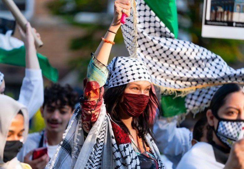 Tanpa mempedulikan terik matahari, Bella Hadid dengan gencar membela tanah kelahiran para kerabatnya.