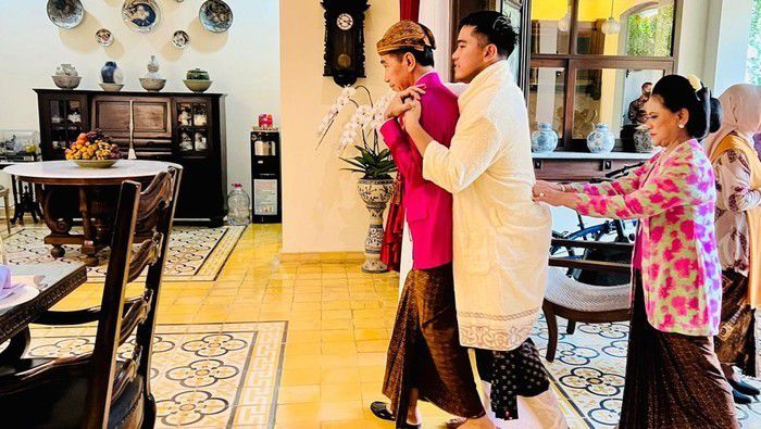 5. Setelah proses siraman selesai, tampak Kaesang yang sudah memakai anduk tersebut berjalan masuk ke rumah sambil memeluk ayahnya dari belakang.   