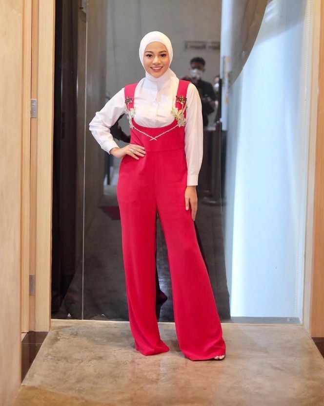 4. Mengenakan jumpsuit berwarna merah dengan hijab putih, membuat penampilan Aurel semakin mempesona.